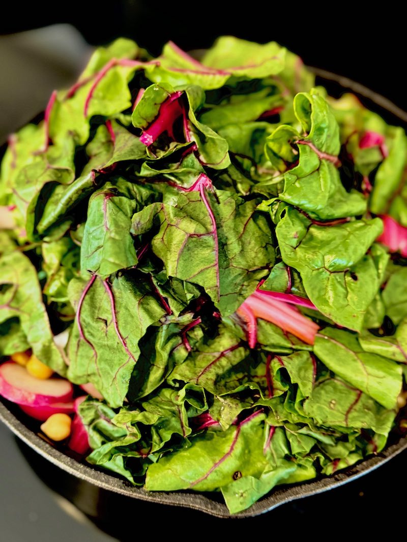 swiss chard and chickpeas cooking with mixed mushrooms and radish