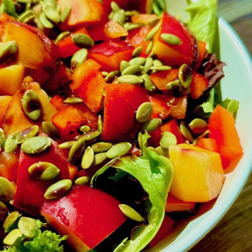 raw vegan salad with greens and pepitas
