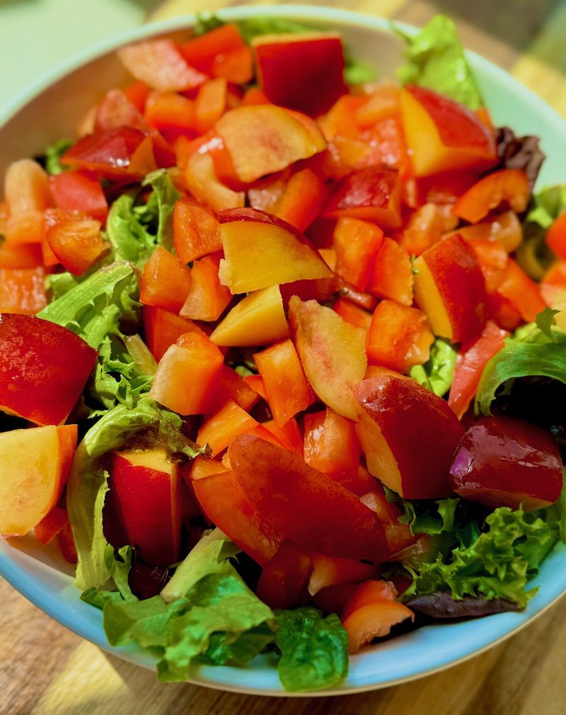 fresh pepper and nectarine on bed of greens