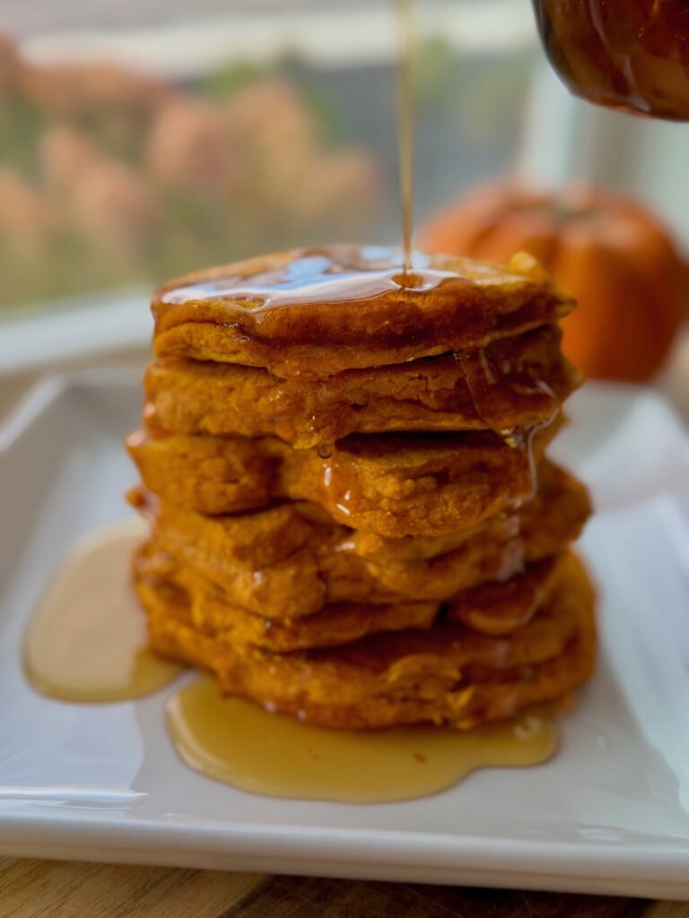 pretty pumpkin pancakes on white plate, with syrup